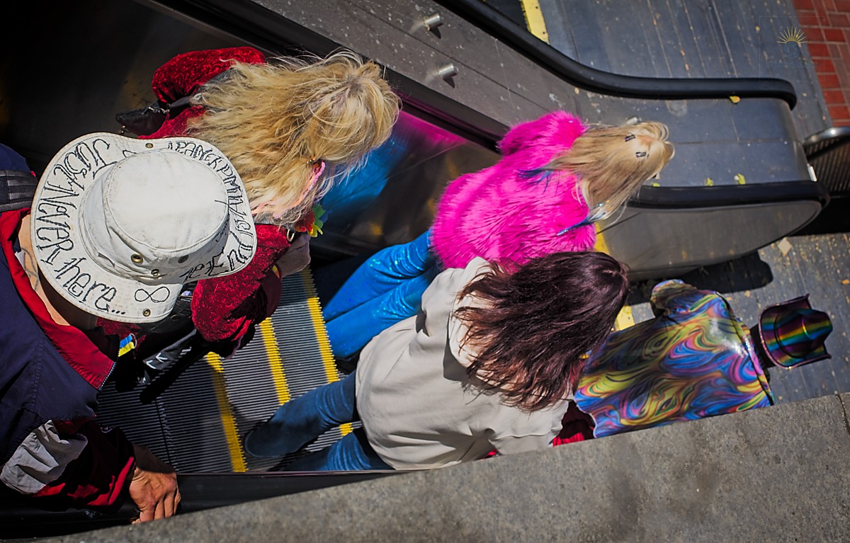 Colorful paradegoers on escalator