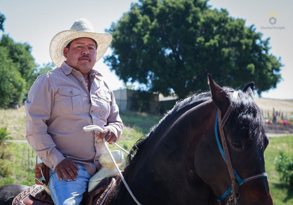 A second rider in a light shirt holds the rope quietly, close to the horse.